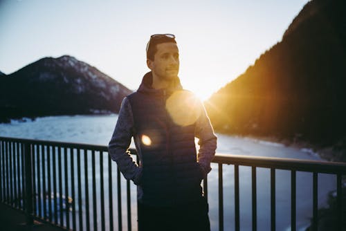 Man Wearing Black Zip-up Jacket Near on the Baluster Railings