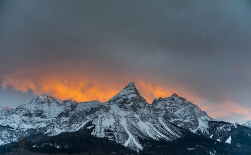 暗い曇り空の下の雪山