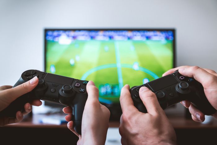 Two people holding game controllers in front of a television