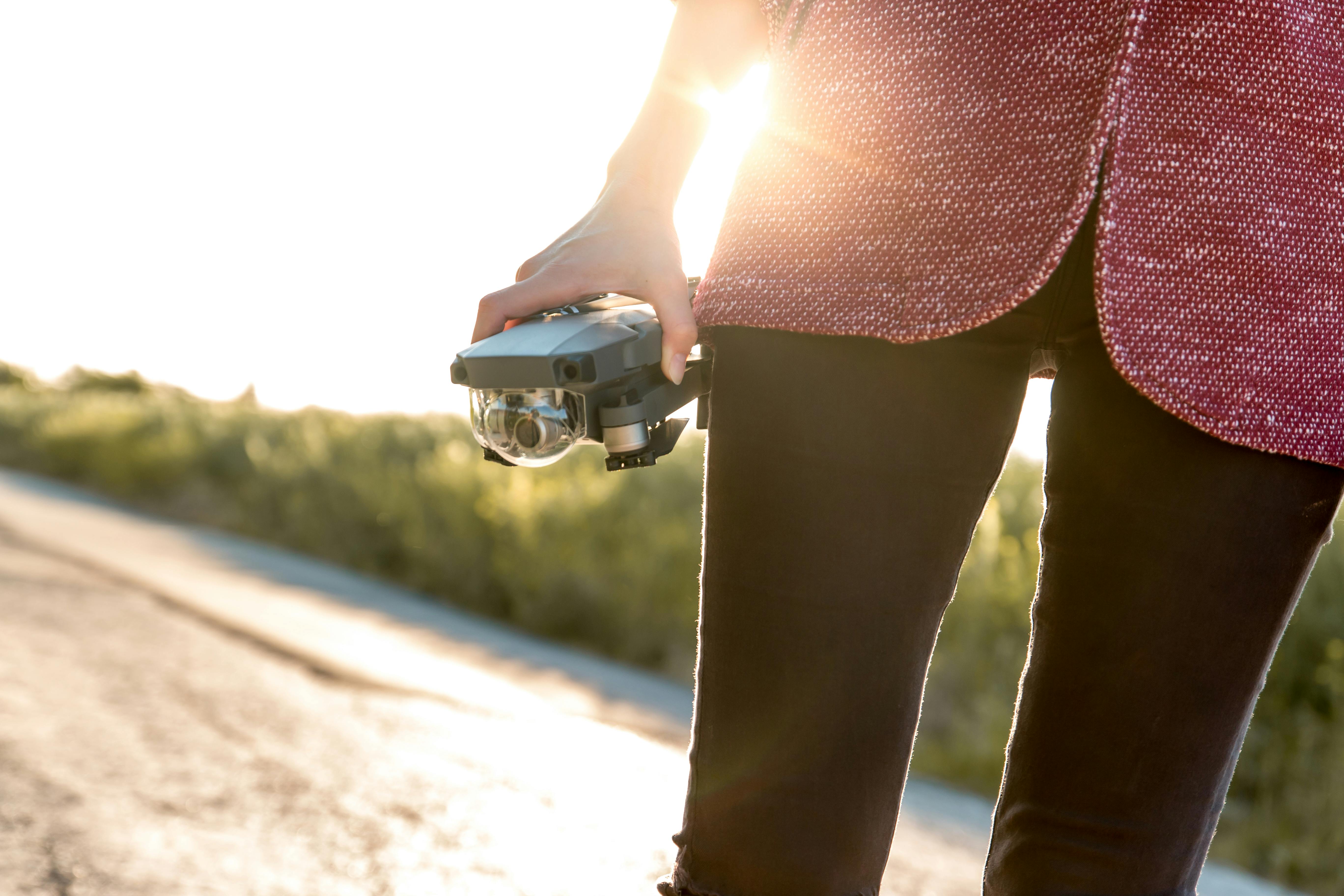 person holding grey drone