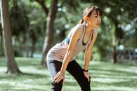 Focused sportswoman resting after training in green park