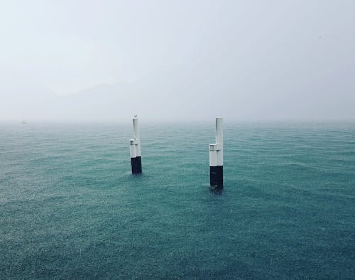 Concrete poles amidst calm blue sea