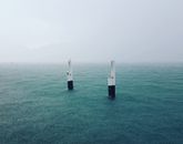 Concrete poles amidst calm blue sea