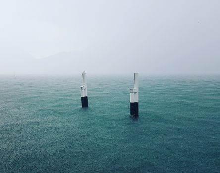 Concrete poles amidst calm blue sea