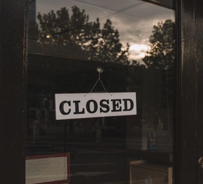 Closed sign hanging on a shop's glass door