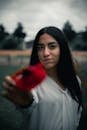 Woman in White Dress Shirt Holding Red Rose