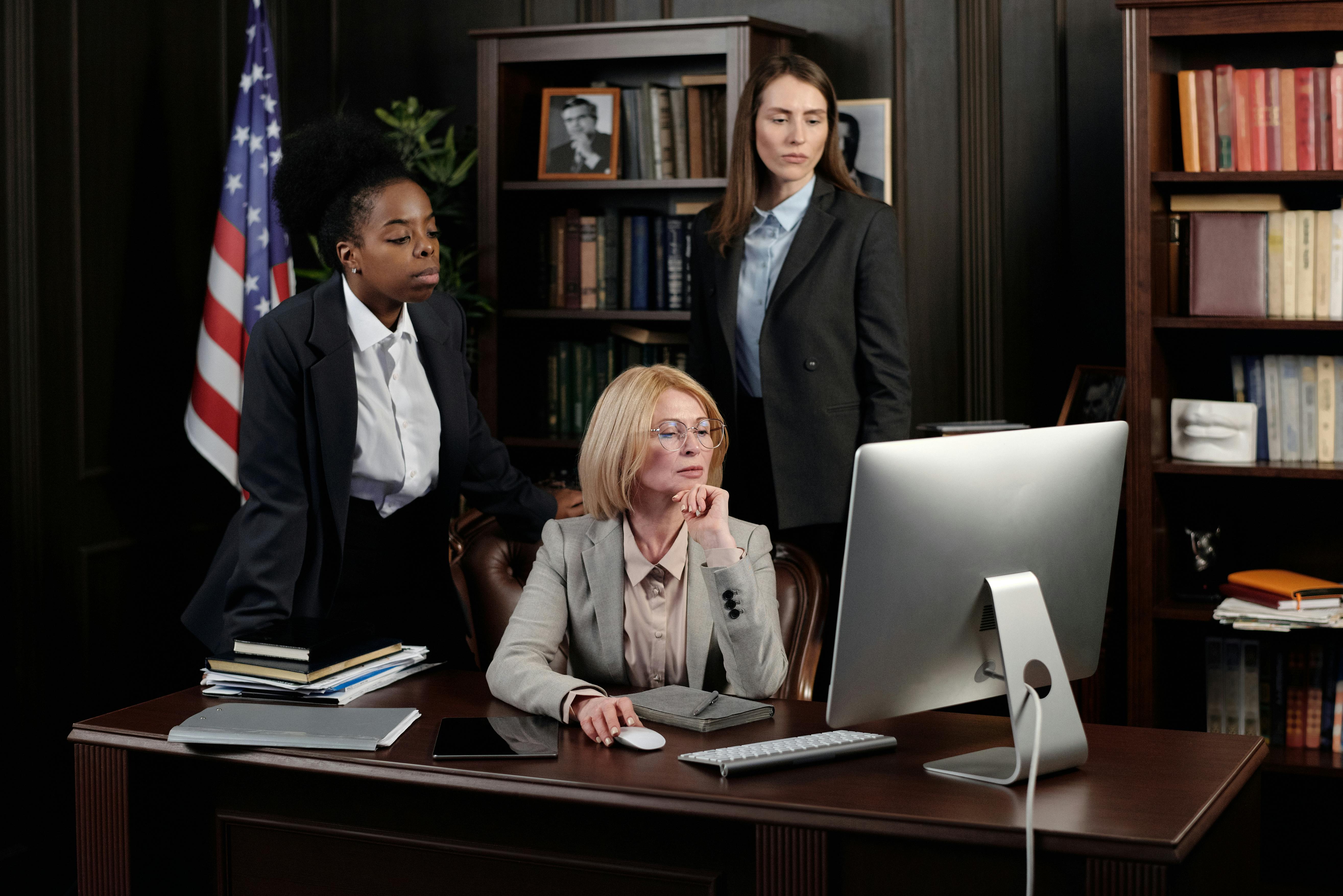 businesswomen in an office looking at a computer