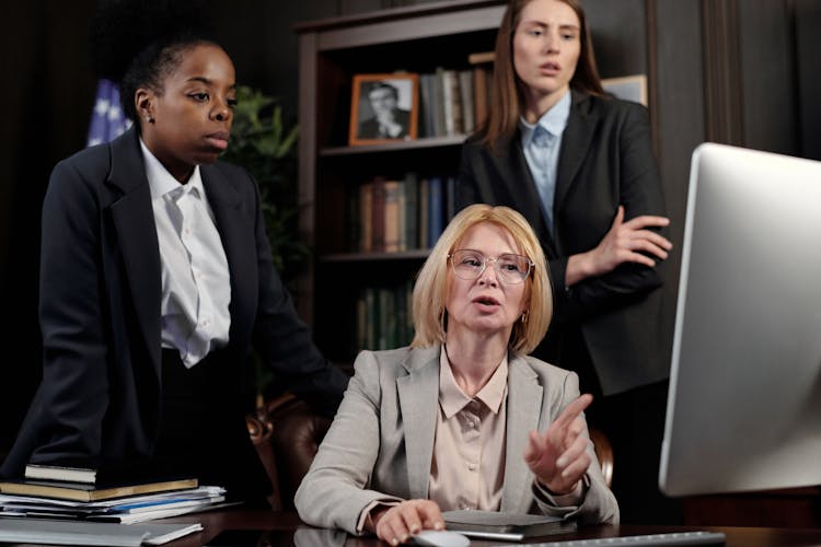 Female Lawyers In An Office Looking At A Computer