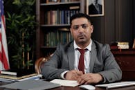 一位严肃的商人穿着西装，在正式的办公室环境中伏案写作