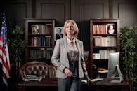 一位自信的女商人肖像，立于优雅的办公室环境中