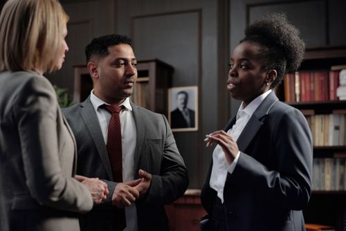 Free Group of diverse professionals discussing in office setting, highlighting teamwork and collaboration. Stock Photo