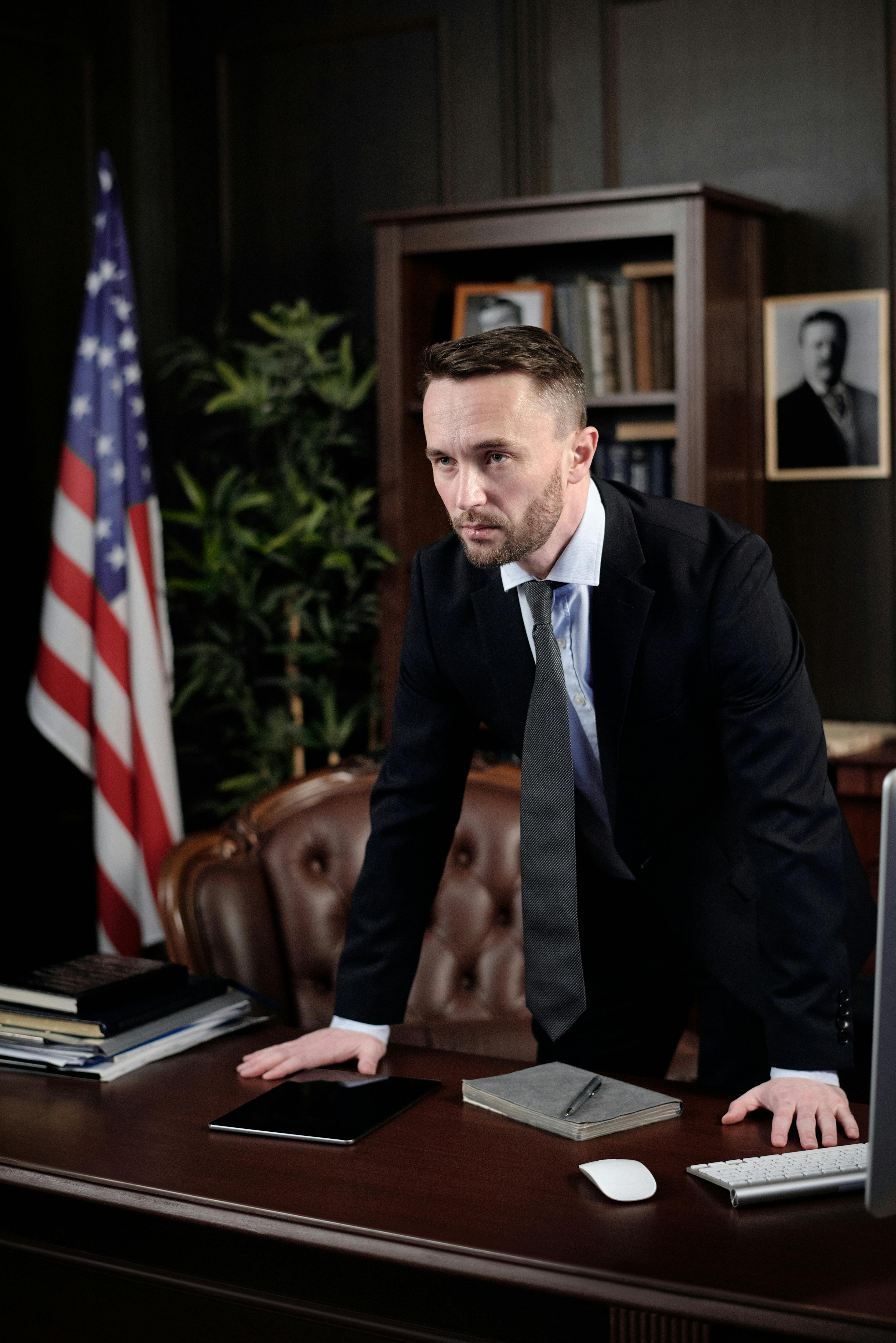 businessman standing with his hands on his desk