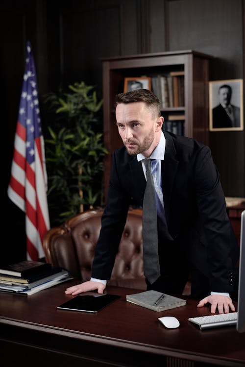 Free Businessman Standing with his Hands on his Desk Stock Photo