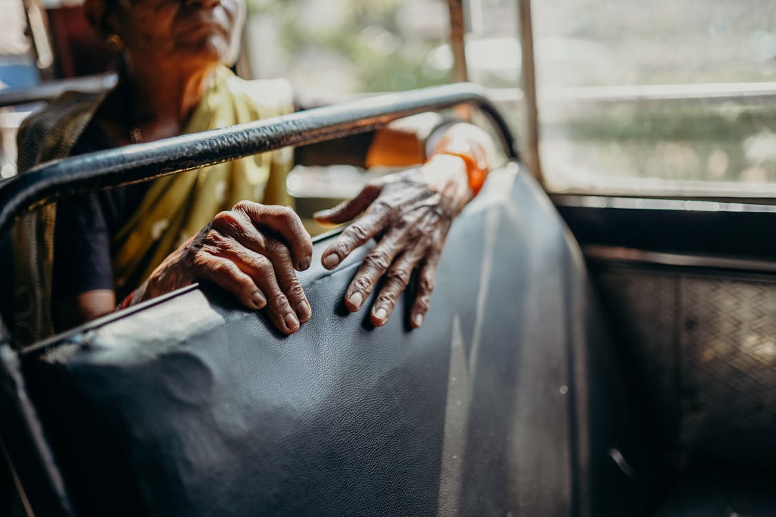 Person in White Long Sleeve Shirt Sitting on Car Seat