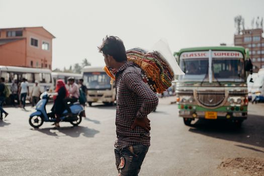 Man in Red and White Plaid Dress Shirt and Blue Denim Jeans Walking on Street during