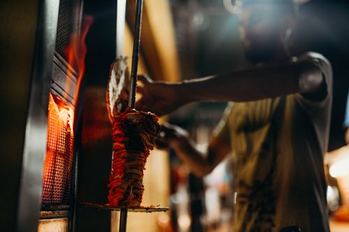 Free Close-up of a chef grilling shawarma on an open flame, showcasing traditional barbecue techniques. Stock Photo