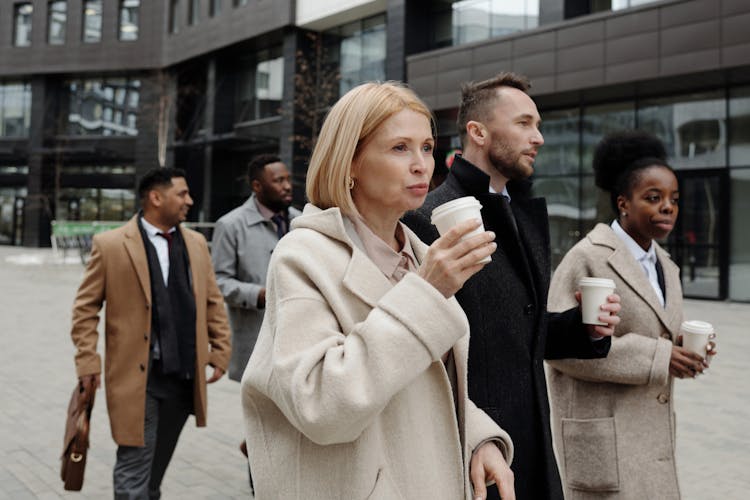 Coworkers Taking A Coffee Break And Walking