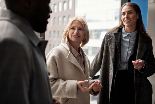 Free A diverse group of business professionals conversing in an urban office setting. Stock Photo