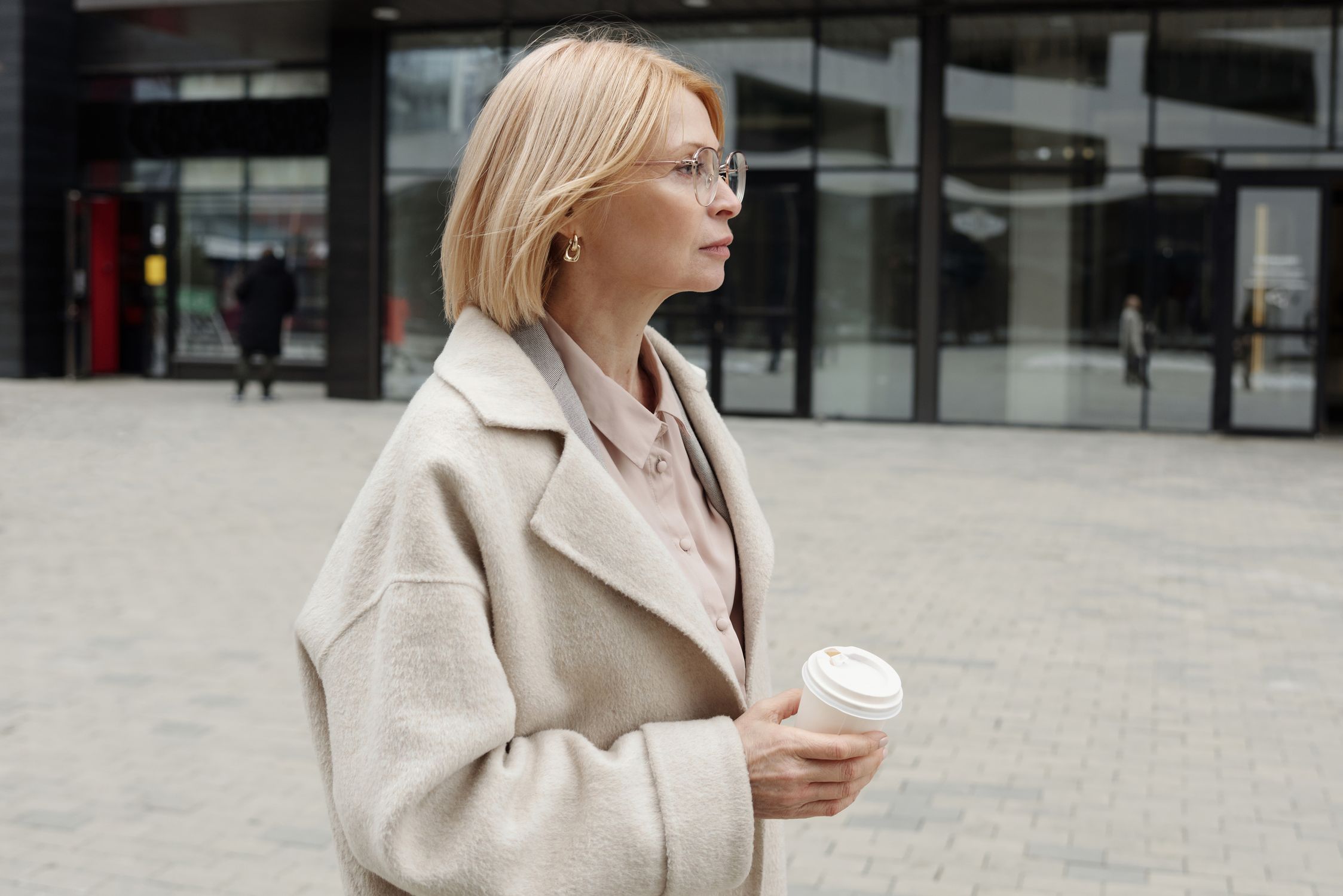 A Woman in Beige Coat Holding a Cup of Coffee · Free Stock Photo