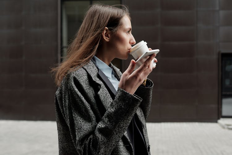 A Woman Drinking A Cup Of Coffee