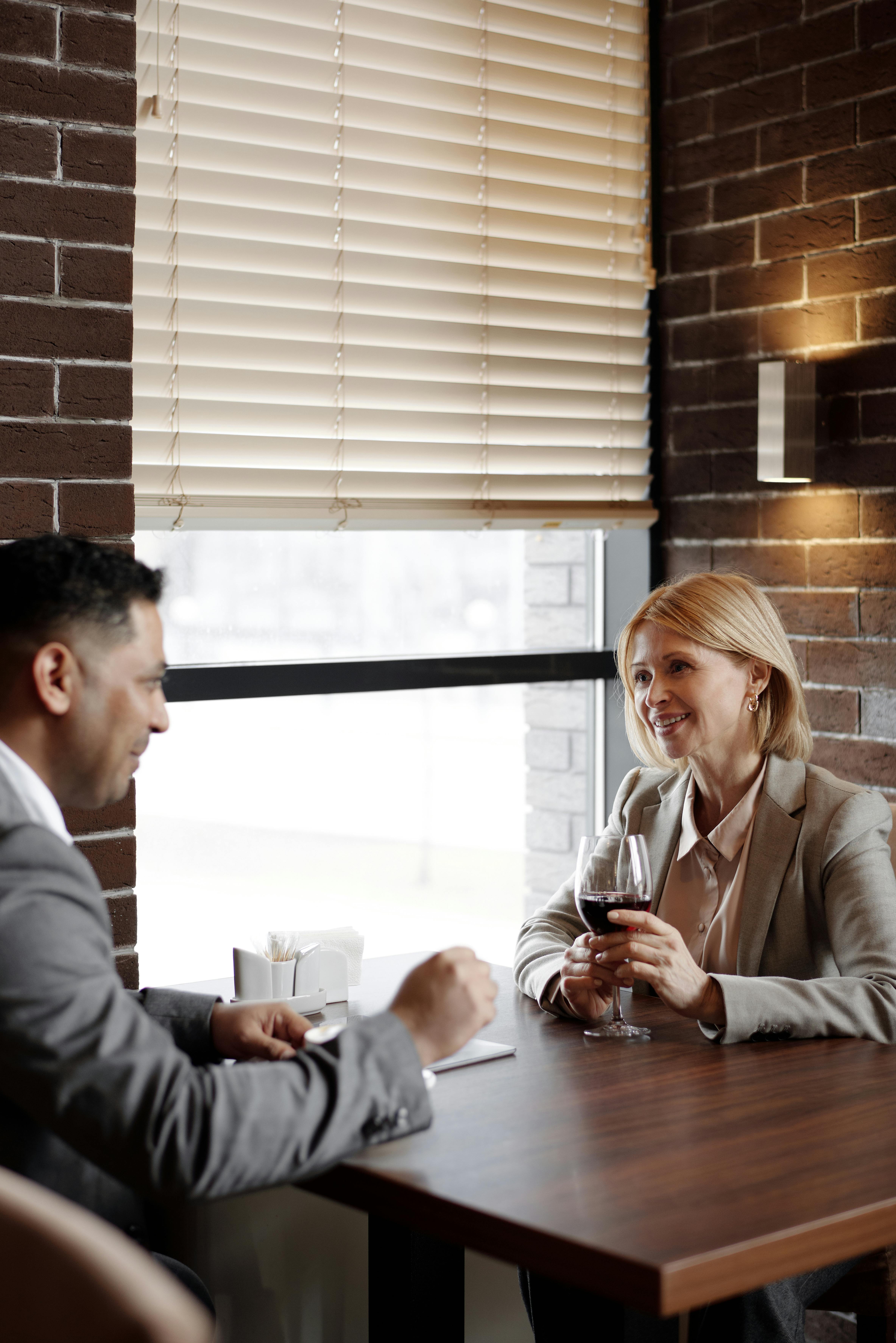 Man and woman sitting at a table. | Photo: Pexels