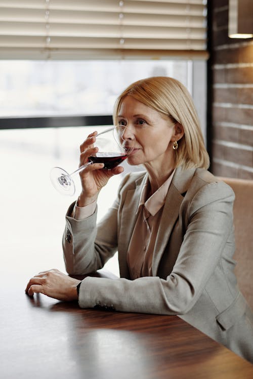 Woman in a Business Suit Drinking Wine