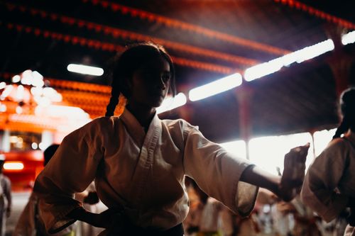 Free Focused young girl in martial arts uniform practices in an indoor dojo setting. Stock Photo