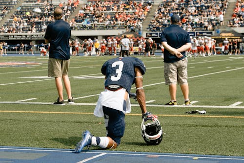 An American Football Player Kneeling on the Field