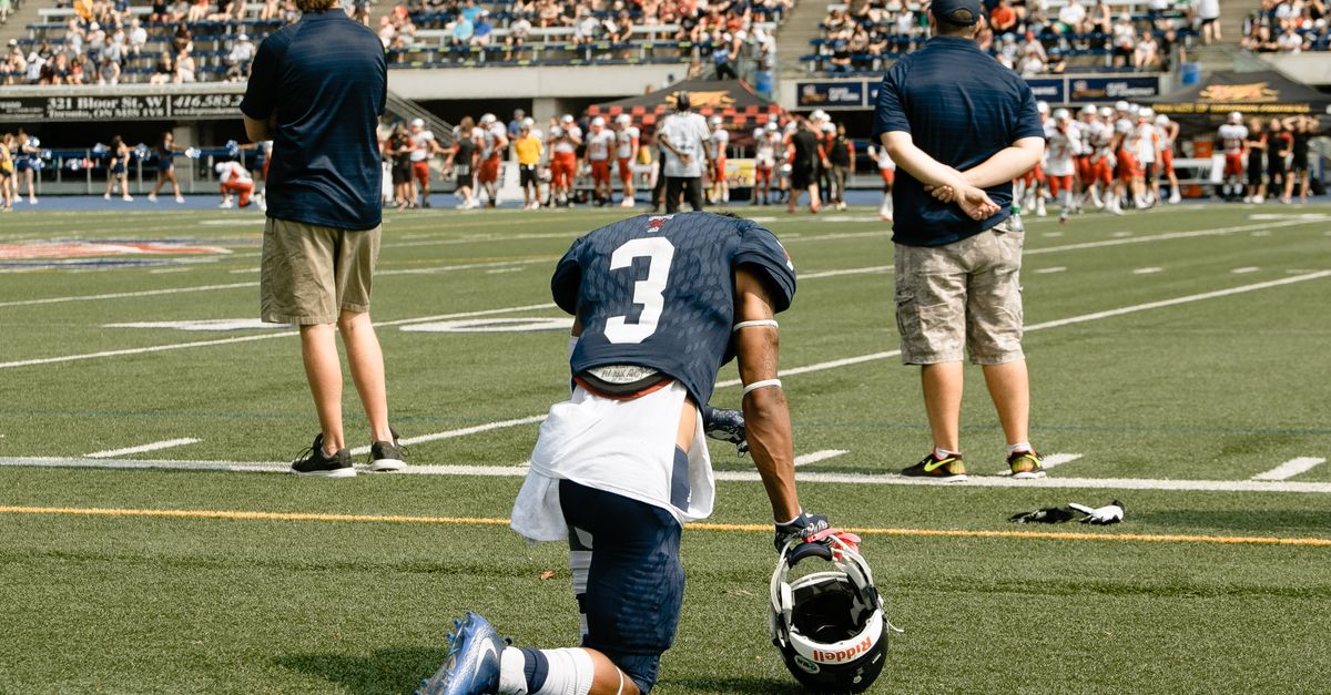 NFL player kneeling during national anthem in empty stadium