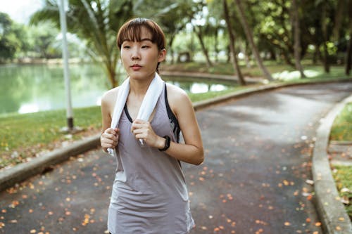 Confident woman with towel running in park