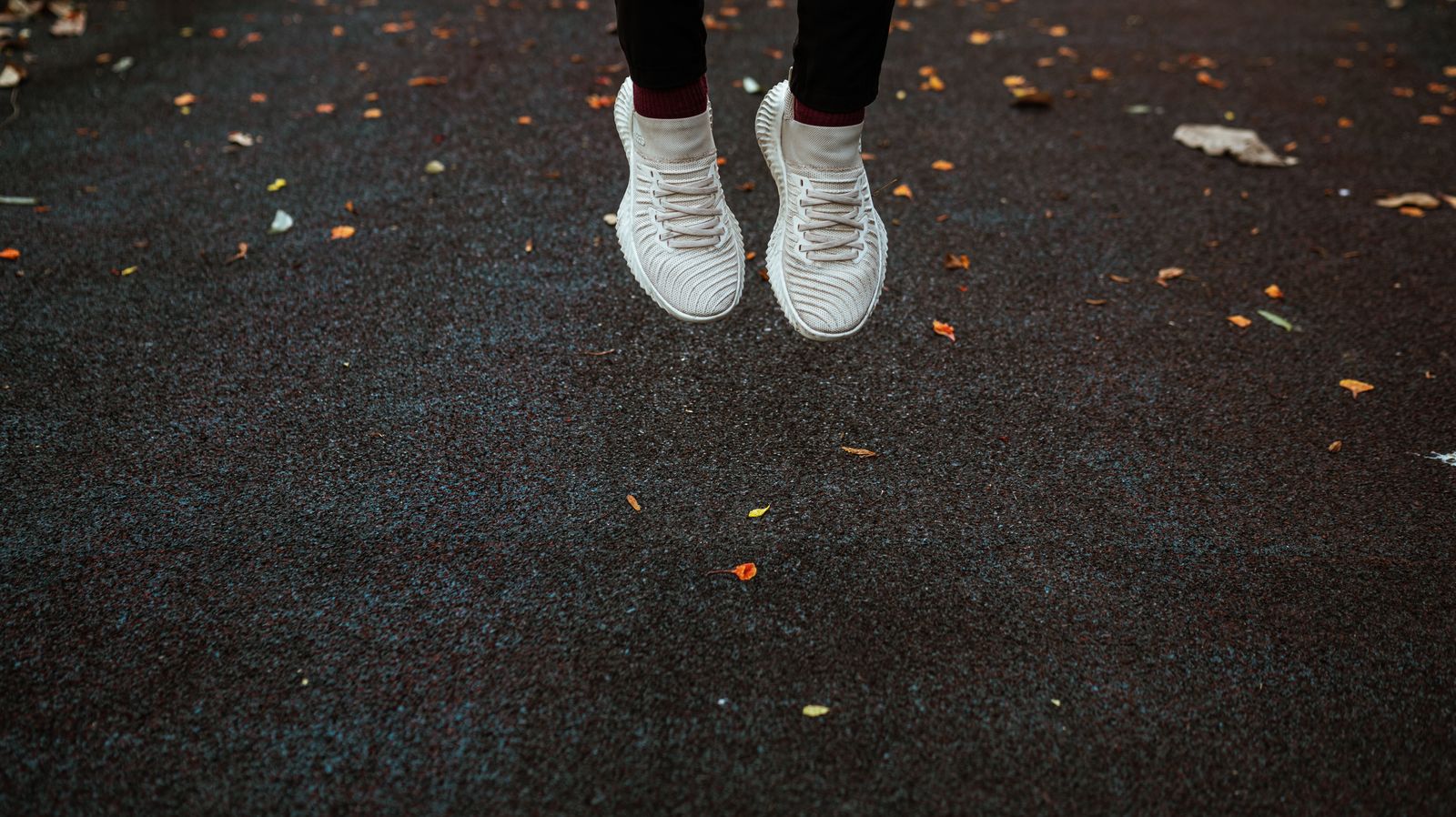 Person adjusting tall compression-style legwear before a bright walk outdoors