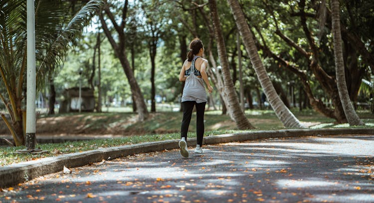 Active Woman Jogging In Empty Calm Park