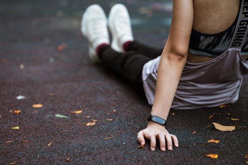 Faceless woman sitting on sports ground