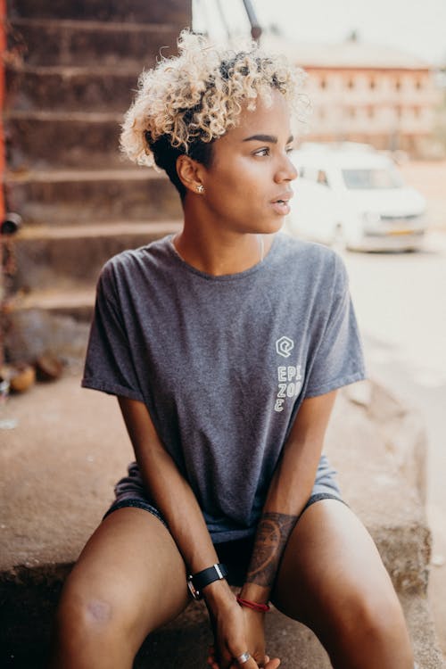 Woman in Gray Crew Neck T-shirt Sitting on Brown Concrete Stairs