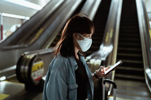 Woman Wearing a Face Mask and Holding a Smartphone