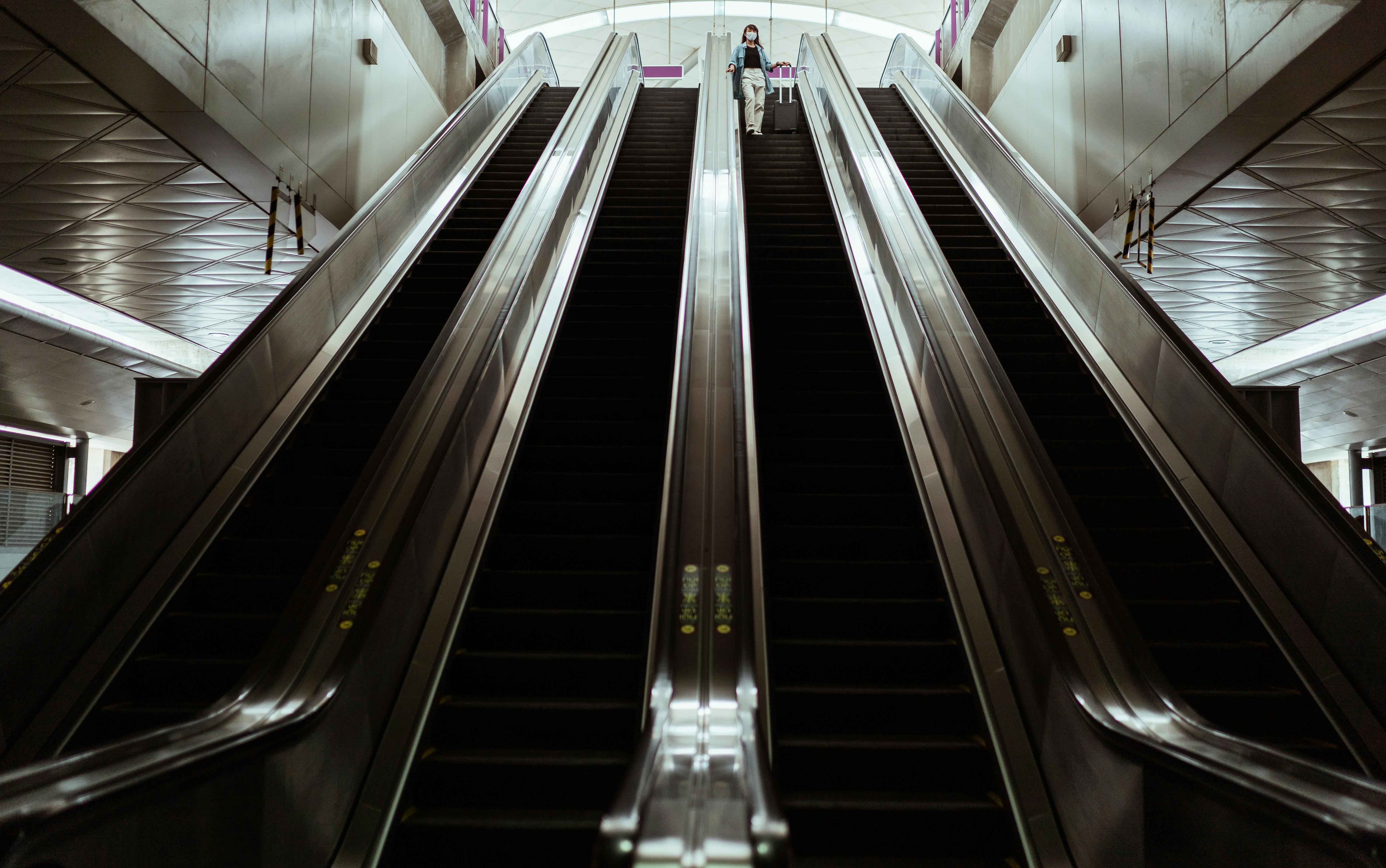 person with a face mask on an escalator