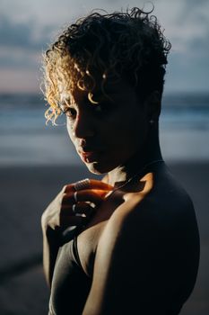 黄昏的海滩上，一位卷发女子的肖像展现了自然之美