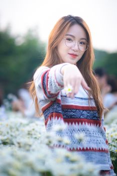 一位开朗的年轻女子站在雏菊地里，享受着夏日的宁静