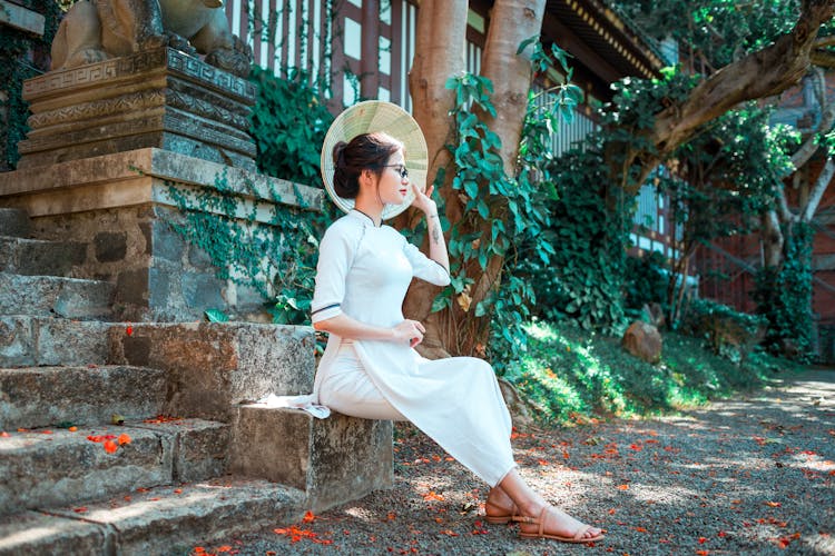 Pretty Young Asian Woman With Straw Hat Sitting On Stairs Of Old Building