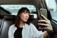 Calm woman taking selfie on smartphone in car