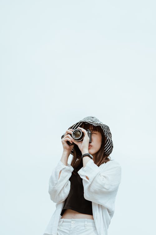 Stylish Asian model taking photo on professional photo camera