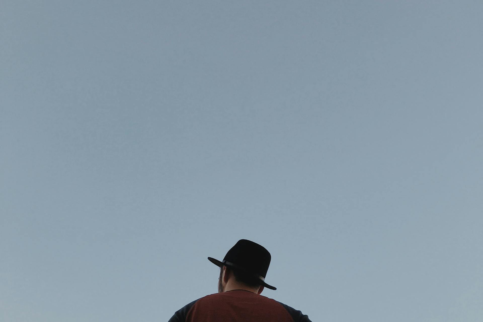 Faceless unshaven man in hat on blue background
