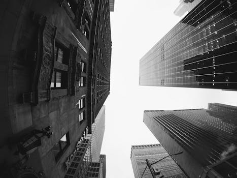 A striking fisheye view of modern skyscrapers against a cloudy sky.