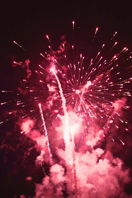 Bright firework with smoke cloud in dark sky at night