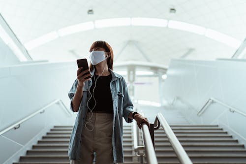 Woman Wearing a Face Mask Walking Down Stairs