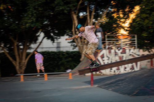 Free Skateboarder performing a trick on a rail in a lively São Paulo skate park. Stock Photo
