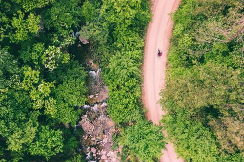 Free Aerial shot of a scenic dirt trail meandering through lush green forest in Stara Zagora, Bulgaria. Stock Photo