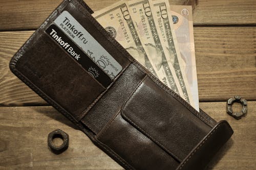 Free Photo of a Wallet with Dollar Bills on a Wooden Surface Stock Photo