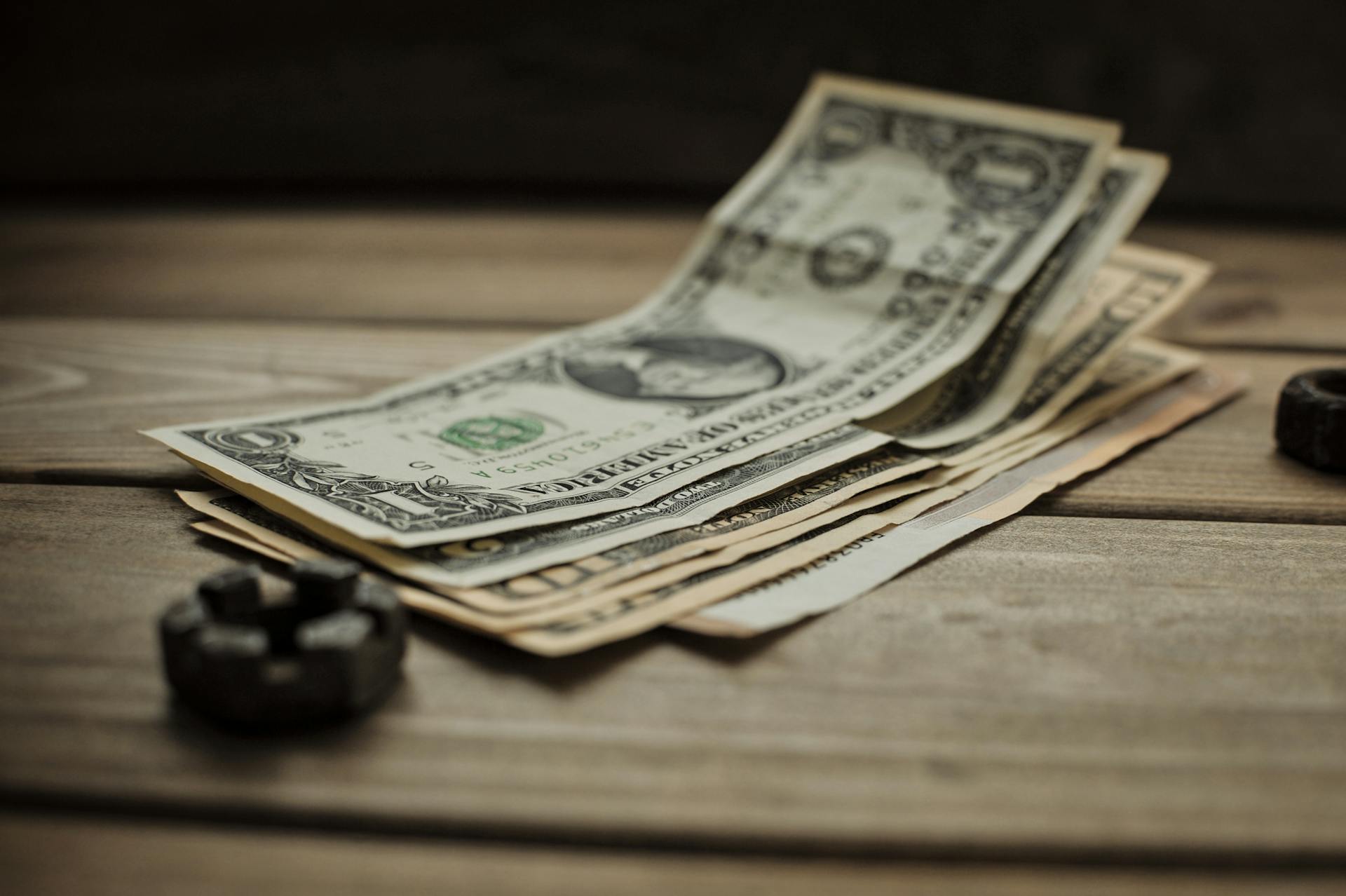 Close-up of US dollar bills on a wooden table, representing finance and commerce.