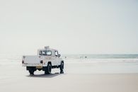 宁静的海滩上停着一辆救生车，人们正在海里游泳